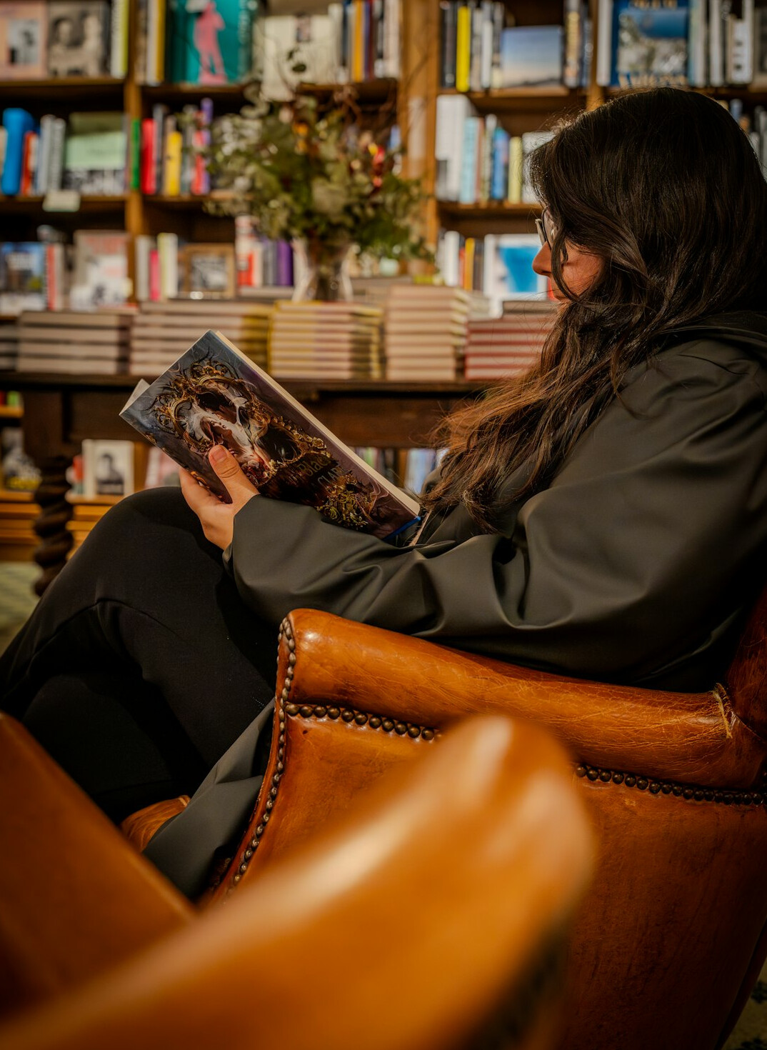 Man with gray hair reading a book in an armchair